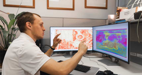 Daniel Irving with graphics depicting soil classifications on Mars.