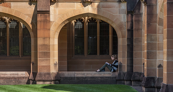 Student sitting in the cloister in the Quadrangle 