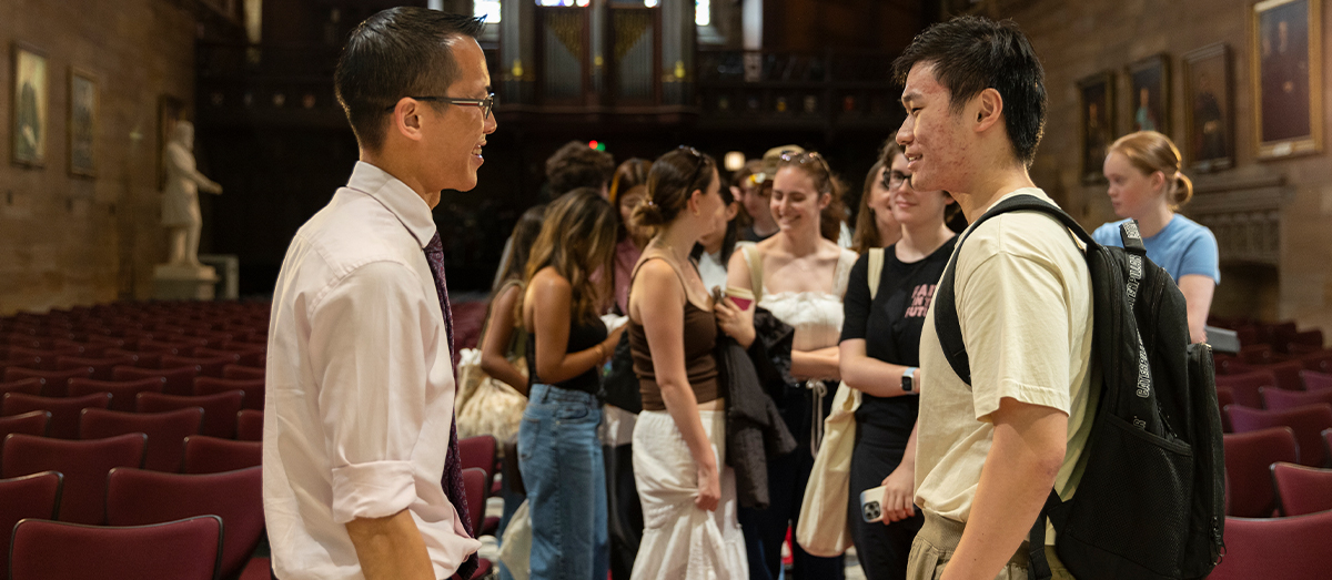 Eddie Woo in the Great Hall chatting with a student