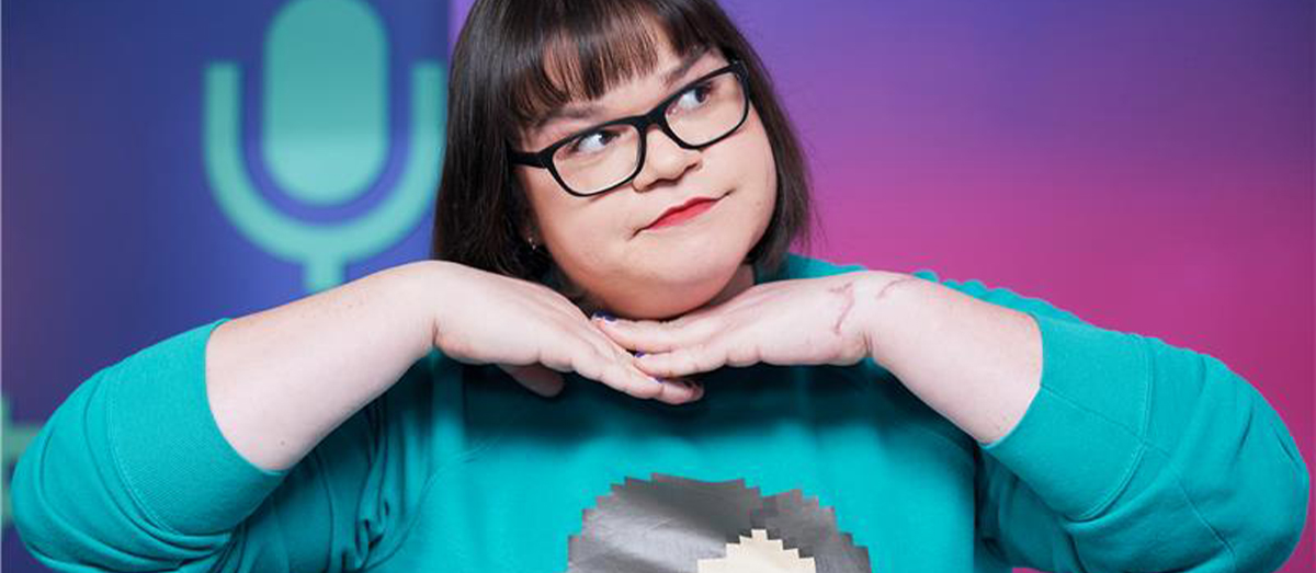 An image of a person, Jordan Raskopoulos, with their hands beneath their chin