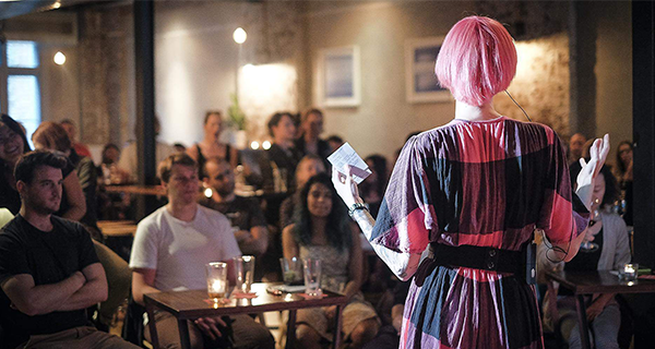 A person presenting a talk in a bar to an audience