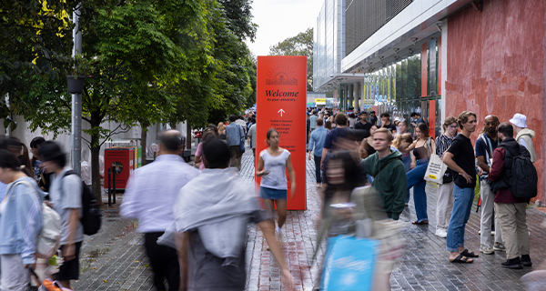 Group of people walking, some blurred, walking down a wide pathway