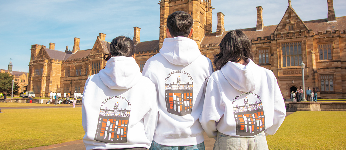 Students wearing last year's hoodie design in front of The Quad