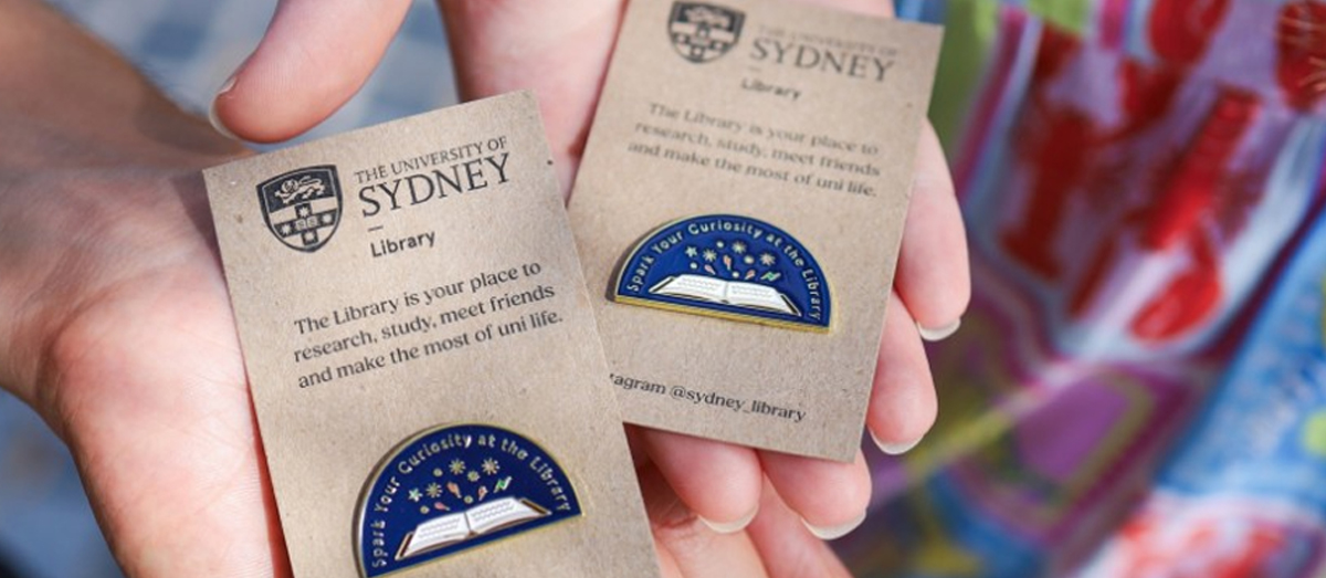 Student holding Library pins
