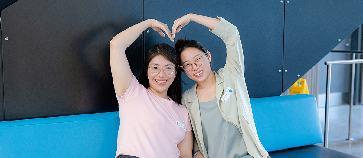 Two students forming a heart