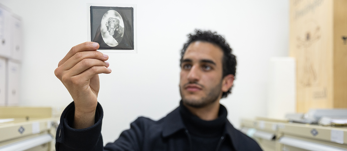 Paul Zaki with lantern slide from Fleay collection at Australian Museum. Credit Renee Nowytarger.