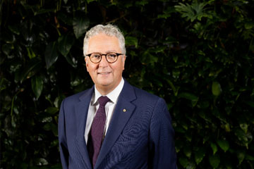 Mark Scott in front of a wall covered in ivy