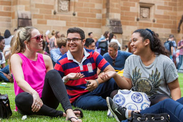 Three students chatting on the quad lawns