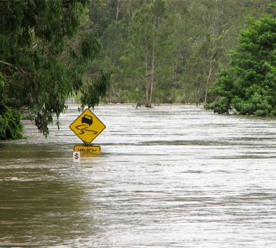 A street flooded up to the road sign