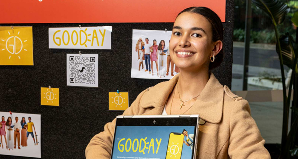 A student standing next to their project display stall.