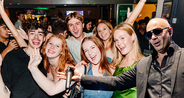 Pitbull superimposed on a photo of students on the dancefloor at Party at Manning