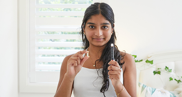 Jasmine holding a pill and a needle