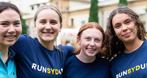 Four students wearing RUNSYDUNI t shirts.
