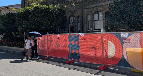 Students walking past a works zone on campus