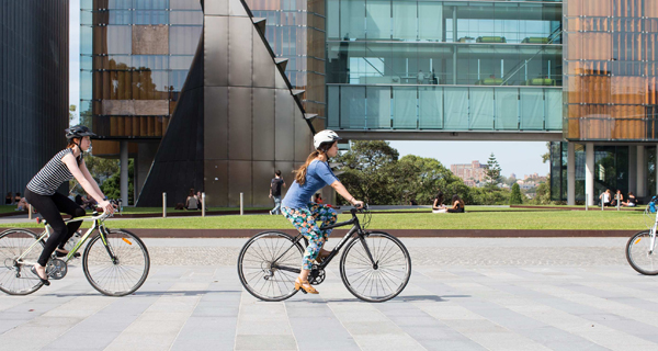 Students cycling in front of Law