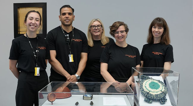 A gorup of museum staff in front of a display case