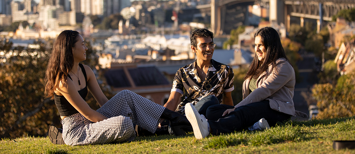 three students in a park chatting