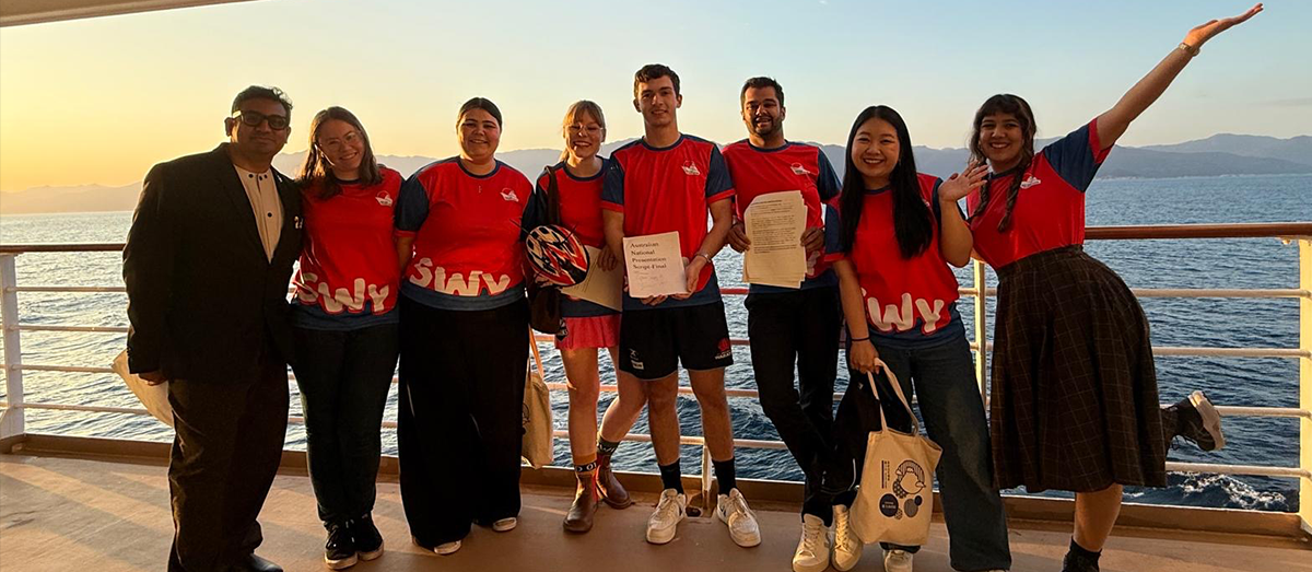 Eight young people standing on a cruise ship.