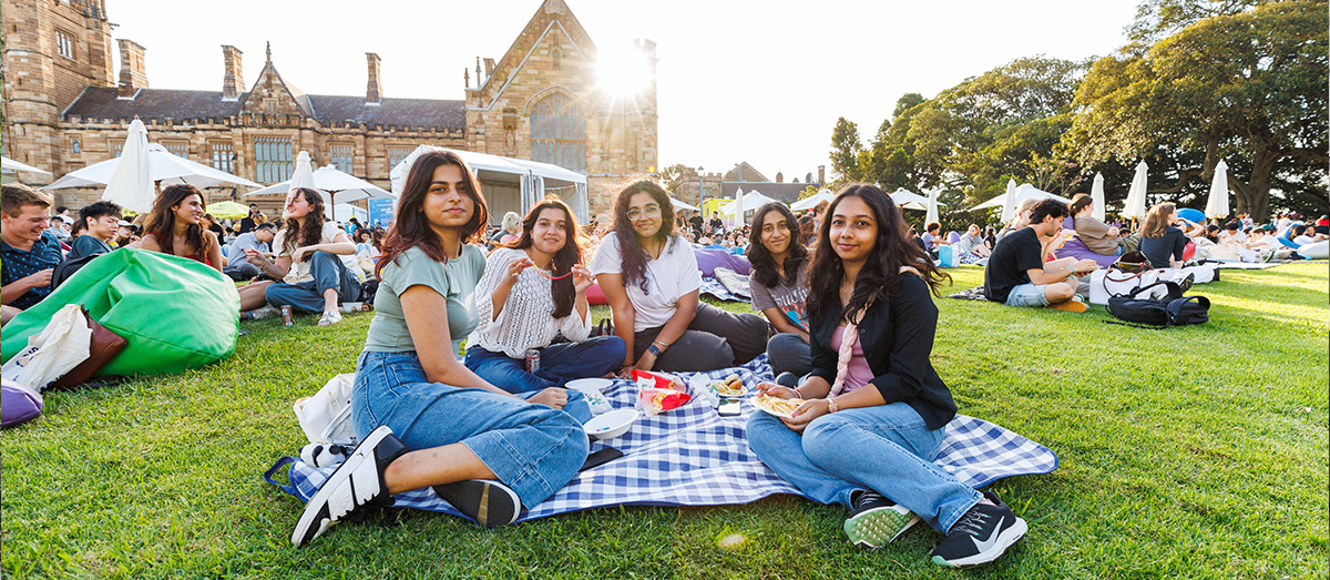 Students sitting on a picnic blanket on the Law Lawns.