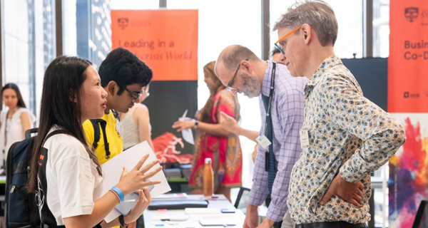 A student and a staff member chatting at welcome