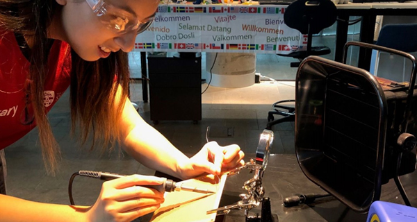 A Peer Learning Advisor demonstrating how to solder