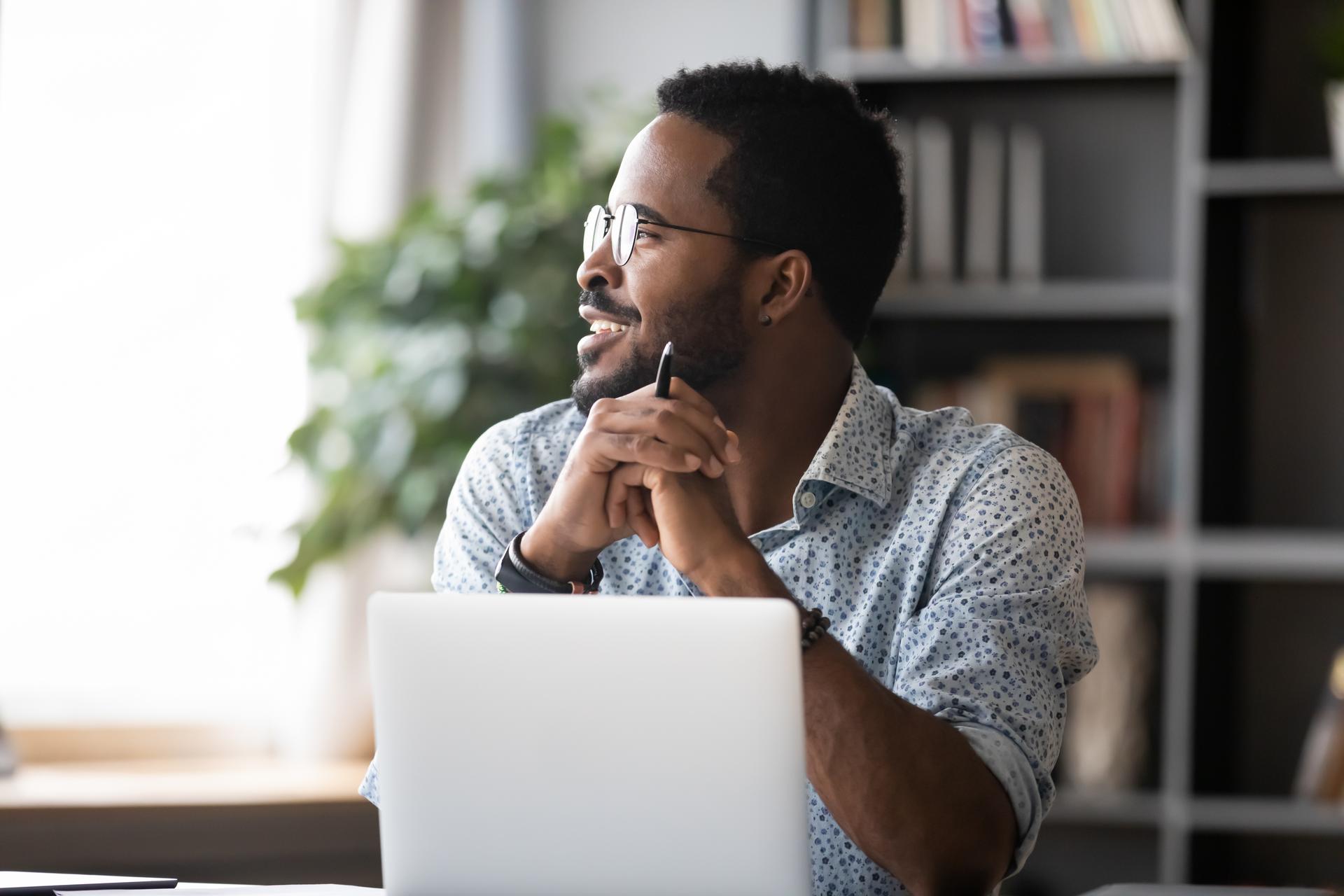 A man on his computer looking out a window