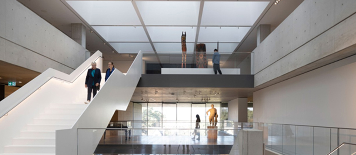 Student standing in between stalls with the Quadrangle clock tower behind them