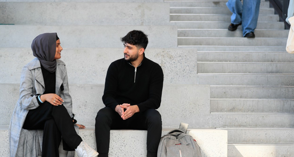 students sitting on the stairs talking at Susan Wakil Health Building